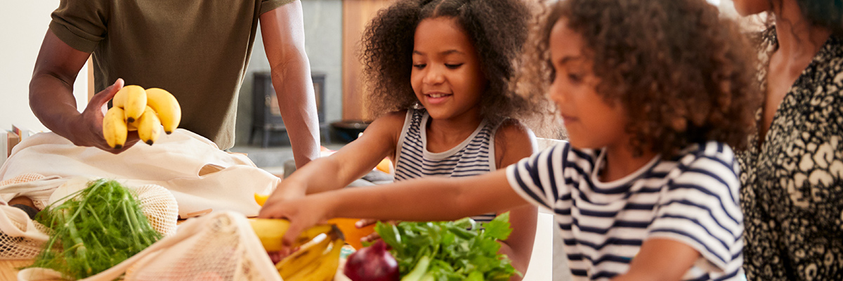 Children picking up fruit from the table